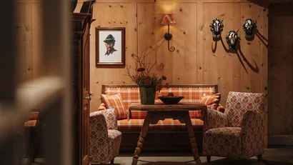 Gemütlicher Holzraum mit orange kariertem Sofa und dekorativen Sesseln