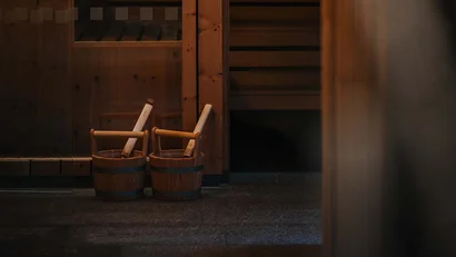 Saunabereich mit Holzwänden und zwei Holzeimern mit Schöpfkellen