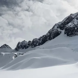 Verschneite Berglandschaft unter wolkigem Himmel