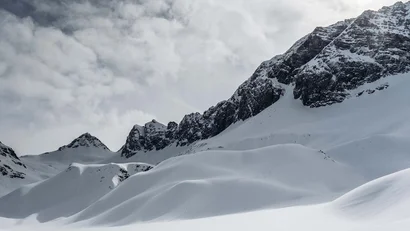 Verschneite Berglandschaft unter wolkigem Himmel