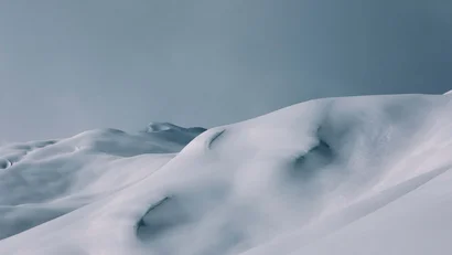 Schneebedeckte Berglandschaft unter grauem Himmel