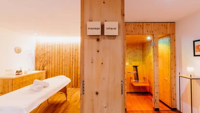 Massageraum mit Infrarotkabine in einem Holzdekor-Spa