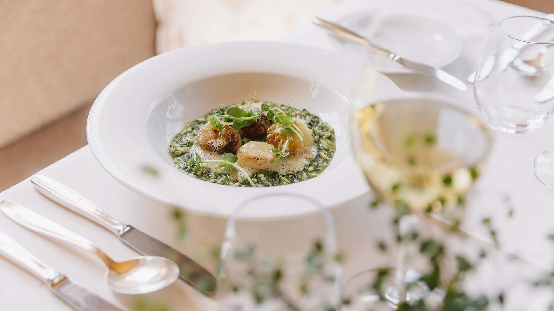 Gedeckter Tisch mit Gourmetgericht und Weinglas in einem Restaurant