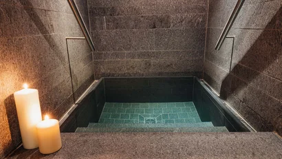 Kleines eckiges Tauchbecken mit Treppe und Kerzen nebenan