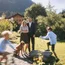 Familie im Garten mit Hund, zwei spielende Kinder, Haus und Berg im Hintergrund
