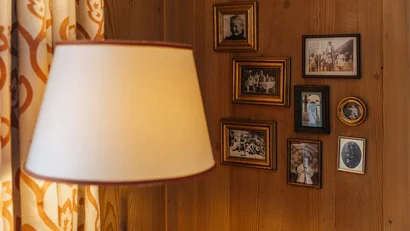 Lampenlicht vor einer Holzwand mit Vintage-Familienfotos