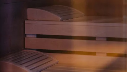 Innenansicht einer finnischen Sauna mit Holzbänken und Rückenlehnen