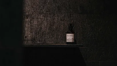 Flasche mit Etikett auf dunklem Wandregal aus Stein