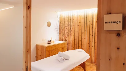 Gemütlicher Massageraum mit Holzelementen und Massageliege