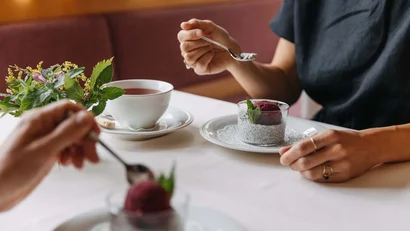Zwei Personen genießen Dessert und Tee an einem Tisch