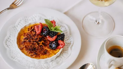 Crème Brûlée mit Beeren und Minzblatt auf weißem Teller