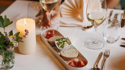 Romantisches Abendessen mit Brot, Aufstrich, Wein und Kerze